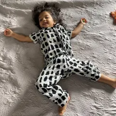 This is what pure comfort looks like. A happy toddler lounging on the bed in our soft cotton pyjama set, completely relaxed and at ease.