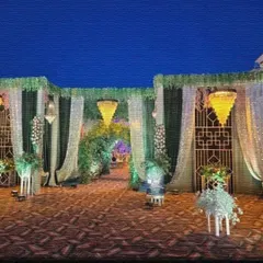 This elegant venue entrance features green and white drapes, sequin curtains, and hanging chandeliers. A floral archway in the center leads guests into the main event area.
