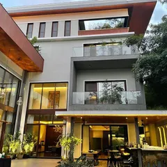 Another view of the Koramangala residence, showing the interplay of different volumes, materials, and the integration of green spaces on multiple levels.