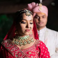 A beautiful candid moment of the bride and groom. Her makeup features a soft-glam eye and a subtle lip, proving that a red lehenga can be paired with a more understated and elegant makeup style.