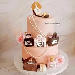 Celebrating a 40th birthday for a true fashionista. This two-tier cake features a collection of iconic, handcrafted luxury items, including miniature bags from Fendi and Prada, a Dior perfume bottle, and a stylish shoe topper.