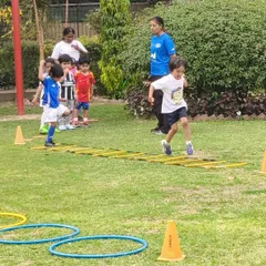 A young player navigates an agility ladder during a First Kicks session. These drills are designed to improve footwork and coordination in a fun, engaging way.