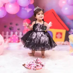 Standing tall and proud after conquering her first birthday cake. This little princess is enjoying every moment of her colorful party setup.