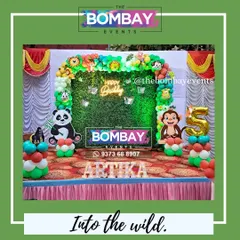Into the wild for a 5th birthday! This jungle theme features a full balloon arch over a grass backdrop, complete with fun animal cutouts and the birthday girl's name in light-up letters.