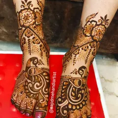 An elegant feet design centered around graceful peacock motifs. The pattern flows beautifully along the natural curve of the foot, adorned with delicate floral vines.