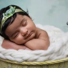 The classic "hands under chin" pose in a basket. This timeless shot highlights the baby's peaceful sleeping face and is a must-have in any newborn gallery.