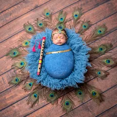 A beautiful overhead view of our 'Chota Krishna' setup. The vibrant blue wrap, peacock feathers, and flute come together to create a stunning and divine portrait.