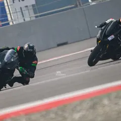 Two riders battle for position, leaning in unison as they navigate a turn. This image captures the close quarters racing and competitive spirit of our track days.