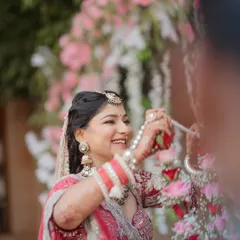 A candid shot of the bride laughing with joy during the Varmala ceremony. These unposed, happy moments are what make your wedding photos truly special and personal.