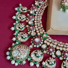 A close-up shot of a statement Kundan set, highlighting the intricate arrangement of uncut stones, pearls, and colored gems. This is the quality your customers can expect.