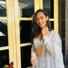 A smile before the start of a wedding reception. This white embroidered outfit was chosen for an elegant evening of celebration.
