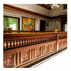 The upper-level gallery overlooking the central living space. The continuous wooden railing, adorned with carved panels, demonstrates our commitment to using craftsmanship to define and enrich interior architecture.