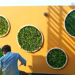 Here you can see me adding the final touches to one of the circular green wall panels, ensuring every leaf is perfectly in place for a full, lush look.