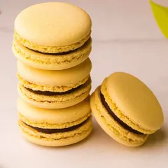 Classic vanilla or hazelnut macarons, with their signature "feet" and smooth shells. They are a testament to the precise technique required to make them perfectly.