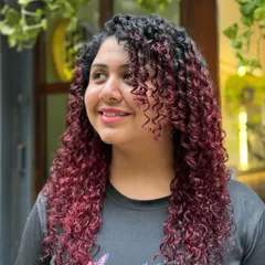 Introducing our "Berry Swirls" color. This vibrant red balayage adds a bold and beautiful statement, especially on tightly defined curls.