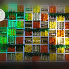 A full view of my signature floral grid backdrop, meticulously arranged with marigolds, tuberoses, and mango leaves. The lighting from behind illuminates the flowers, creating a warm and festive glow for a baby shower.