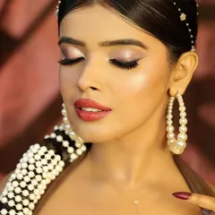 A soft and dreamy close-up with eyes closed, emphasizing the delicate eyeshadow and highlighter.