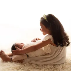 Their divine love. This beautiful moment between two sisters just melts my heart. The way big sister looks at her new baby is pure magic.