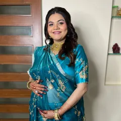 A full-length view of this beautiful mom-to-be. Her elegant blue saree is paired with soft makeup and a classic half-up hairstyle, making her look and feel special for her baby shower.