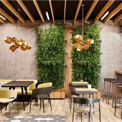 For this cafe, we created a warm and eclectic atmosphere using a mix of textures. The design combines exposed brick walls, statement green walls for a touch of nature, and varied seating arrangements including booth, bar, and table seating to cater to different customer groups.