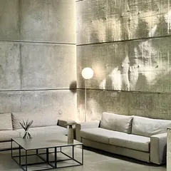 In the 'House of Stories', light from unseen sources washes over the textured concrete walls, making the hard material feel as soft as fabric. This effect is central to our design philosophy of using light as a primary architectural material to shape mood and perception.