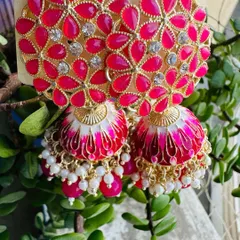 These rani pink meenakari jhumkas are a crowd favorite. The bright pink floral top is paired with a beautifully painted dome, making it a perfect match for lehengas and suits.