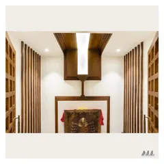 The interior of the Pooja room before placing the idols. The design features a dramatic wooden ceiling element with a central light, flanked by vertical wooden slats that add texture and warmth.
