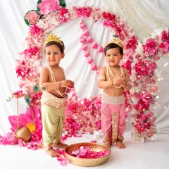 Double the trouble, double the cuteness! These two little Krishnas are ready for some mischief in this beautiful pink floral setup.