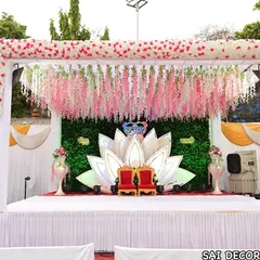 Here is another example of my lotus theme engagement decor. This setup includes a mandap with hanging pink flowers, a green wall backdrop, and a large lotus cutout for the couple's seating.