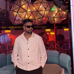 A candid shot in a club lounge with unique lighting. This captures the cool, relaxed vibe I embody before stepping behind the decks to turn up the energy.