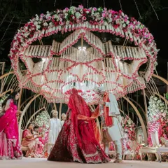 The Varmala ceremony under a spectacular Lotus-themed mandap. The ceiling is a breathtaking creation of hanging white and pink florals, forming the shape of a blooming lotus.