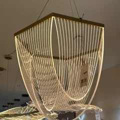 An example of modern art meeting light. This geometric chandelier uses flowing lines of light to create a sense of movement, perfect for a contemporary dining or living space.
