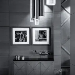 A monochrome view of a console area, highlighting the textures and forms. The custom sideboard with starburst marquetry is paired with black and white photography, showcasing our attention to curated details.