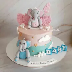 A cute baby shower cake with pink and blue elephants. The design is perfect for a gender-neutral celebration, with soft pastel colors and little stars.
