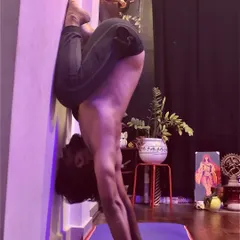 Using the wall for support in this deep inversion helps to refine alignment and build confidence. This variation of a handstand tuck requires core engagement and controlled breathing to maintain stability.