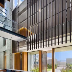 The reception area at the Laxcon office features a minimalist palette of ribbed oak paneling and exposed concrete. We integrated the client's own product, using stainless steel for partitions and structural elements to celebrate the company's identity.