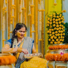 The bride participates in the Haldi rituals, surrounded by beautiful yellow floral decor, a picture of grace and tradition.