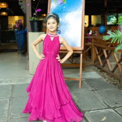 Here is the birthday girl posing in her custom gown. You can see the beautiful draping of the fabric and the way the color stands out, making it a truly special outfit for her 6th birthday party.