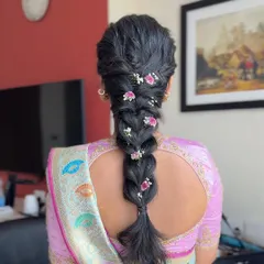 A close-up of a textured, messy braid adorned with small flowers. This romantic hairstyle is perfect for a bride or bridesmaid looking for something soft and elegant.