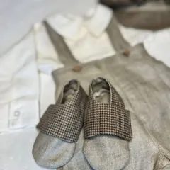 A close-up of the handmade soft shoes and linen-blend fabric from our vintage-inspired beige suit set for boys.
