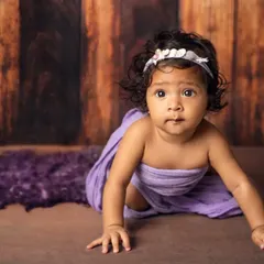 Look at that determination. This six-month-old is practicing her crawling skills during her purple-themed milestone photoshoot.