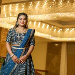 A full-length view of a modern reception outfit. The makeup is balanced to complement the detailed lehenga, with a focus on creating a radiant complexion that shines in the festive atmosphere.