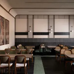 We created different zones within the large restaurant space. This section uses clean wall paneling and a mix of seating types, including custom cafe seating solutions, to offer a varied dining experience under soft, ambient lighting.