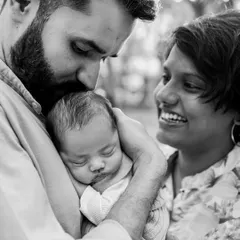 This black and white photo of a father kissing his newborn's head while the mother looks on with a smile is pure emotion. It's a perfect example of how monochrome images can feel so intimate and heartfelt.