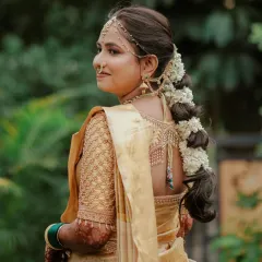 A detailed look at the back of Dhanashree's hairstyle, featuring a thick braid adorned with fresh jasmine flowers (gajra), a staple for Marathi brides.