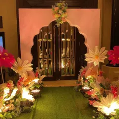 We created a magical entrance for the cradle ceremony, lining a green turf walkway with oversized, illuminated paper flowers and leading to a grand, floral-adorned archway.