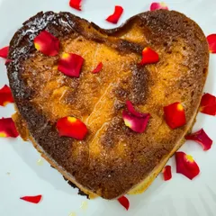 A perfect gift for your loved ones, our Sweet Heart Chhenapoda. It's the same authentic baked cheese dessert you love, presented in a heart shape and garnished with rose petals.