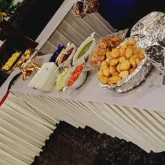 A deconstructed pani puri station with all the elements laid out for guests. This includes puris, various fillings, and different types of flavored water (pani).