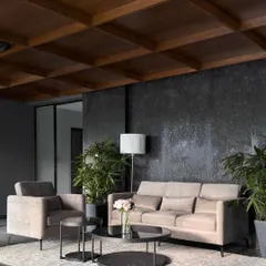 A comfortable waiting lounge adjacent to the reception. The space is characterized by a textured black granite wall, a warm wood ceiling, and plush, modern furniture for visitor comfort.