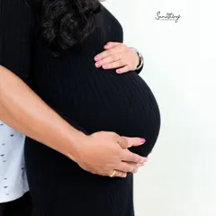 A close-up shot focusing on the hands of both parents cradling the baby bump. This simple yet powerful image represents the love and protection surrounding their unborn child.